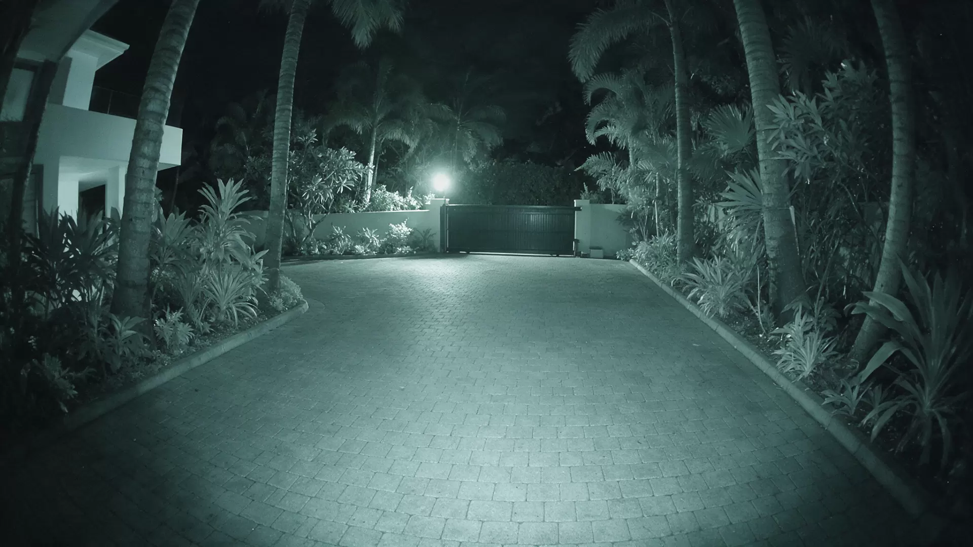 Night-vision camera view of the villa driveway